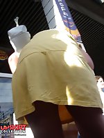 Upskirt pictures - Yellow mini cannot save her from being voyeured. Up skirt